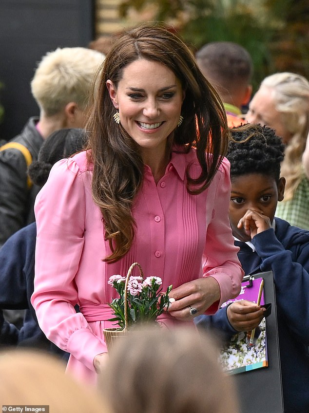Kate looked thrilled with her present of a potted plant in a basket as she strolled through the grounds