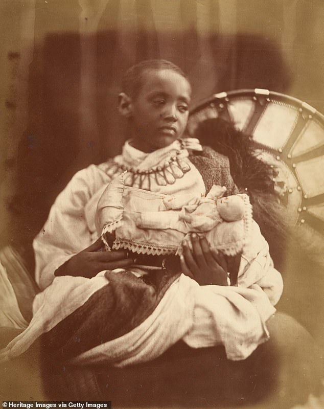 Der junge verwaiste Prinz hält eine kleine weiße Puppe in den Armen und starrt ins Leere