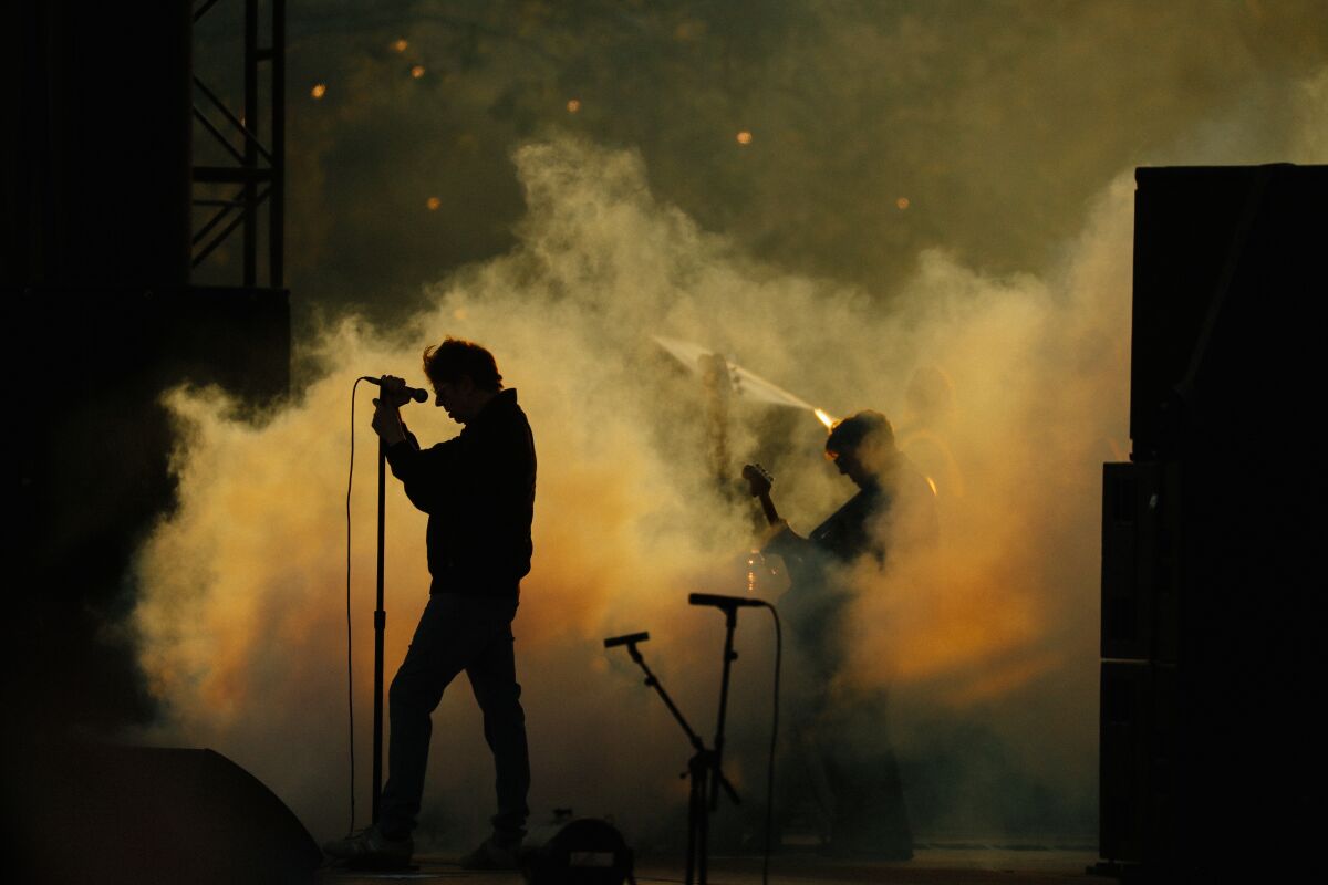 Eine Band tritt in Rauchwolken auf der Bühne auf.