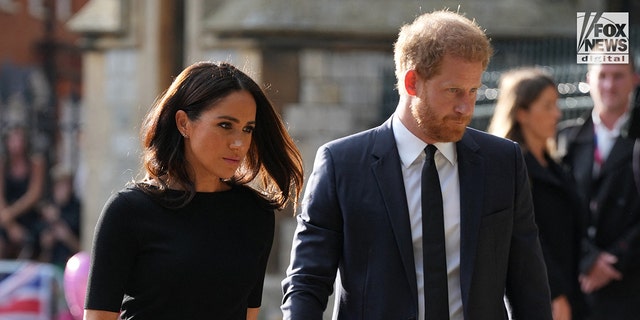 Die niedergeschlagene Meghan Markle in einem schwarzen Kleid und Prinz Harry in einem schwarzen Anzug und einer schwarzen Krawatte vor Windsor Castle, nachdem die Königin gestorben war