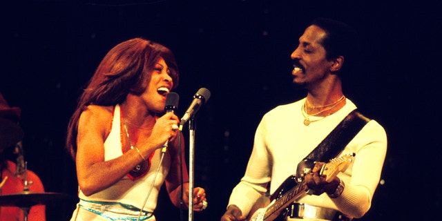 Tina Turner tritt in einem weißen Kleid an der Seite von Ike Turner auf.