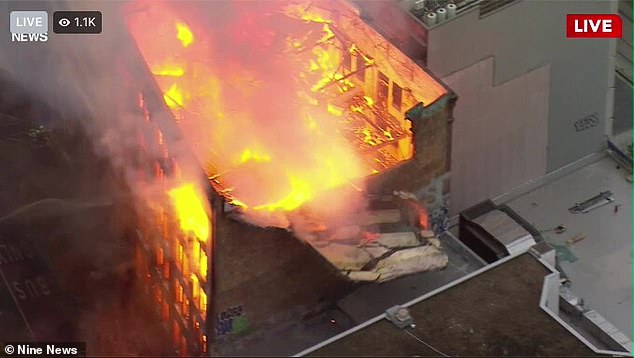 Ein gewaltiges Inferno brennt ein Gebäude neben Sydneys geschäftigstem Bahnhof nieder – und hat sich bereits auf einen nahegelegenen Apartmentkomplex und mindestens ein Auto auf der Straße davor ausgebreitet