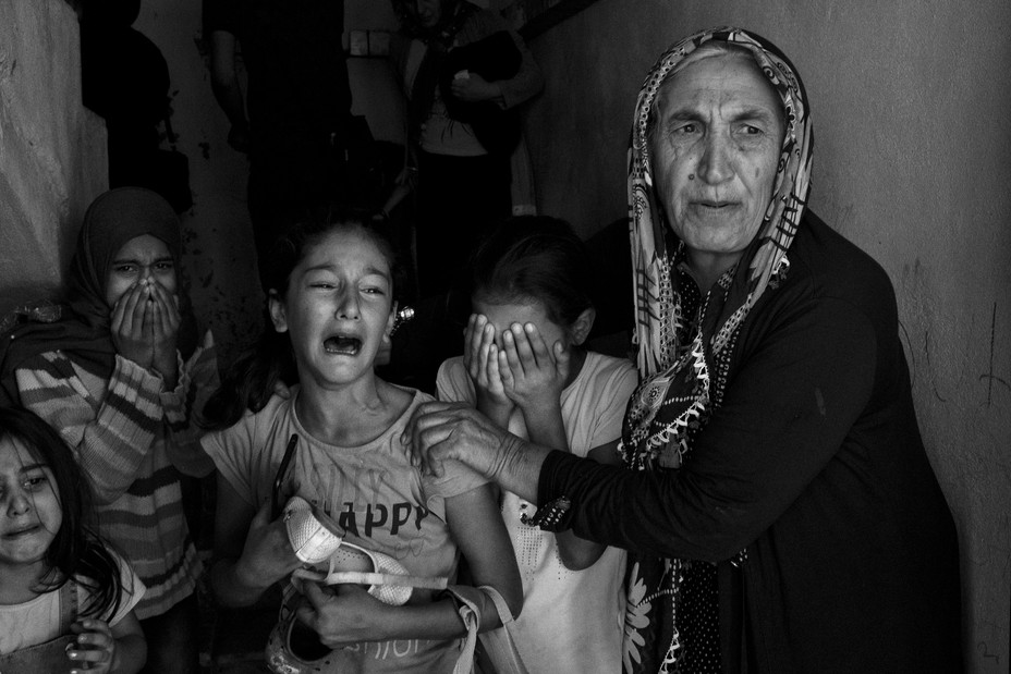 Bild von Menschen, die unter Schock auf der Flucht sind und aus ihren Häusern fliehen, während an mehreren Orten in Akcakale, Türkei, weiterhin Mörsergranaten einschlagen.