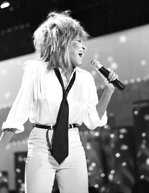 Bei einem ihrer lässigeren Looks trägt Tina 1984 eine schwarze Krawatte, eine weiße Bluse und eine Hose