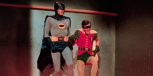 Batman und Robin in Kostümen hüpfen herum
