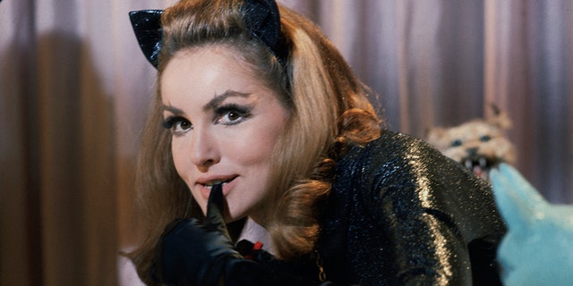 Julie Newmar beißt sich im Kostüm als Catwoman in den Daumen