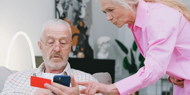 Altes Paar schaut auf das iPhone