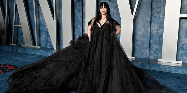 Billie Eilish in einem ausgestellten schwarzen Kleid auf dem roten Teppich von Vanity Fair für die Oscar-Afterparty