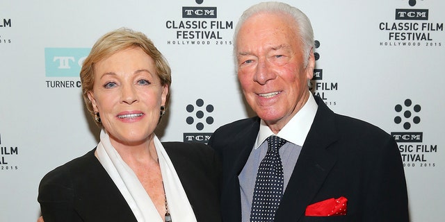 Julie Andrews and Christopher Plummer smiling while posing next to each other on the red carpet