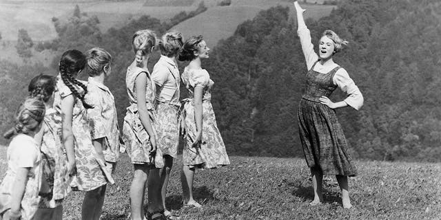 English actress and singer Julie Andrews as the young nun Maria, teaching the von Trapp children to sing