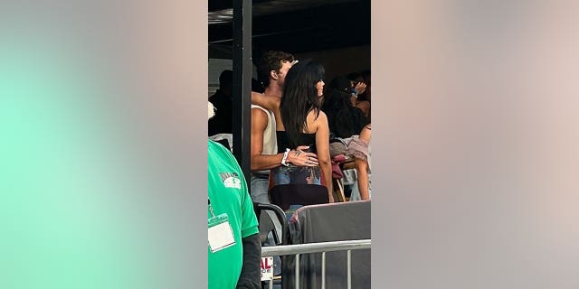 Camila Cabello in Schwarz legt bei der Taylor Swift Era's Tour ihren Arm um Shawn Mendes Hals, die Hand hinter ihrem Rücken