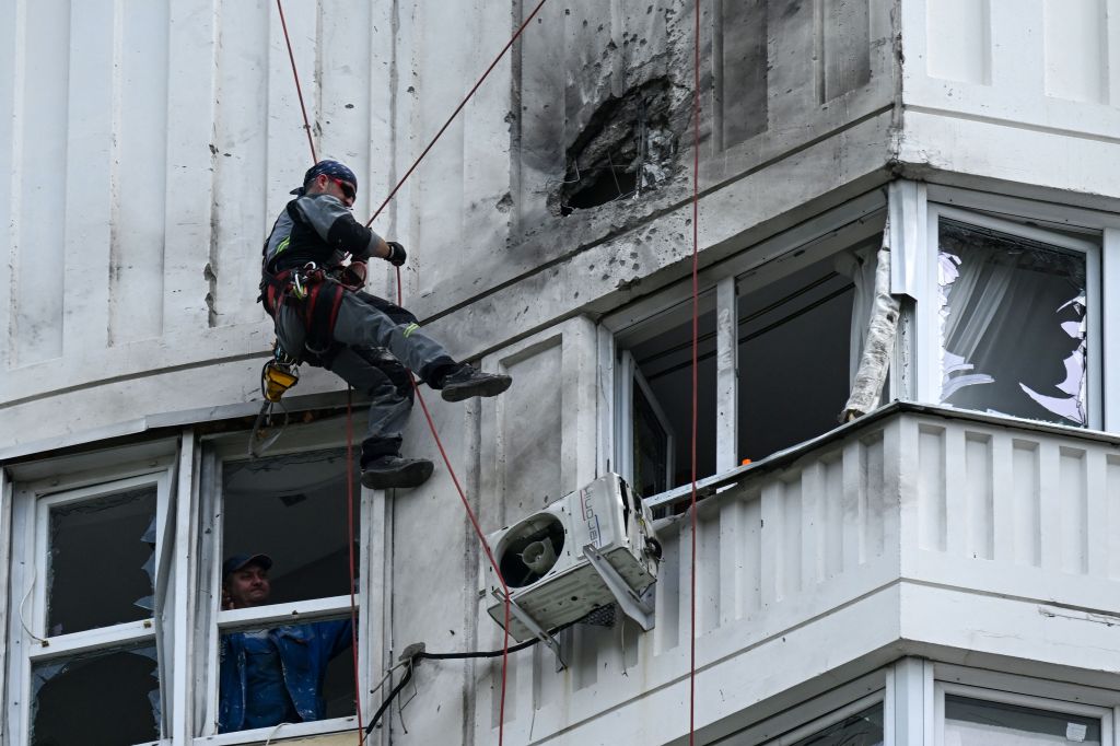 Ein Spezialist inspiziert die beschädigte Fassade eines mehrstöckigen Wohnhauses nach dem Drohnenangriff in Moskau.