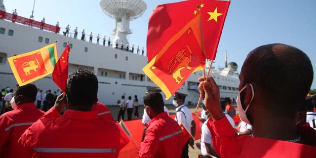 In Sri Lanka schwenken Menschen chinesische Flaggen
