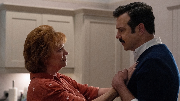 Teds Mutter Dottie mit ihren Händen auf seiner Brust, er hält sie in einer Szene aus Ted Lasso.