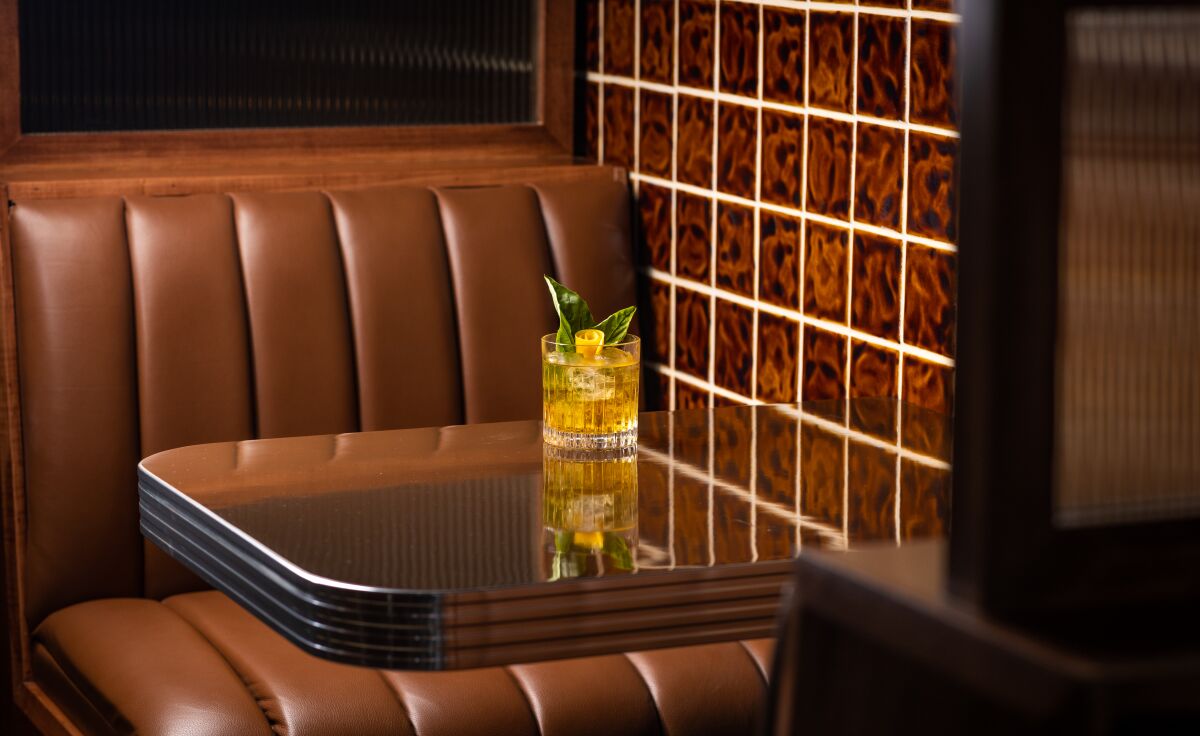 Ein Cocktail auf einem Tisch an einem braunen Restaurantstand