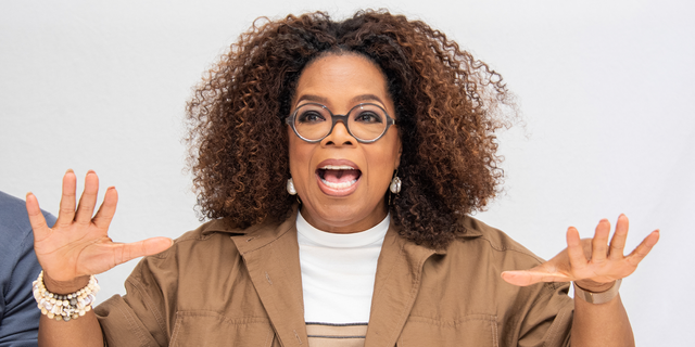 Oprah Winfrey wedelt bei einer Veranstaltung lebhaft mit den Händen.