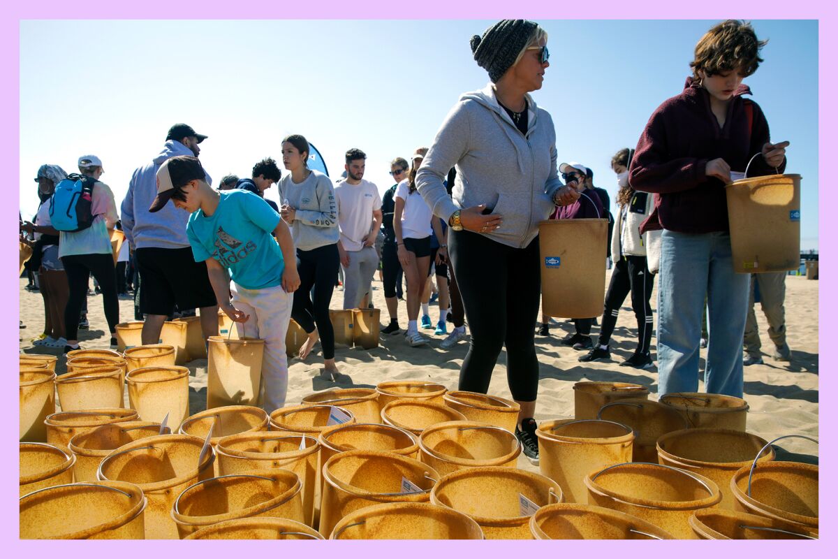 Freiwillige sammeln Eimer, um an der von Heal the Bay in Santa Monica, Kalifornien, organisierten Nothin' But Sand Cleanup teilzunehmen.
