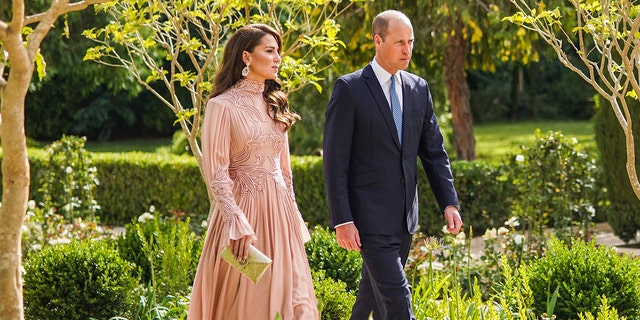 Kate Middleton in a blush gown next to Prince William in a blue suit