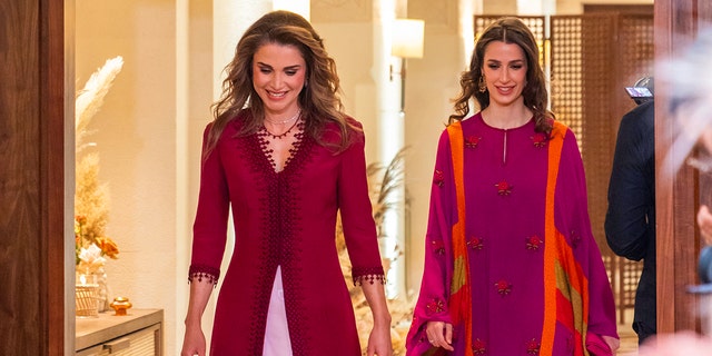 Queen Rania and her daughter-in-law Princess Rajwa wearing burgundy gowns at a henna party