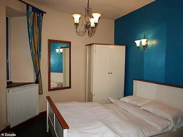 Es gibt zwei Schlafzimmer in der Unterkunft, darunter dieses mit einer geschwungenen Seite und einer farbenfrohen Wand