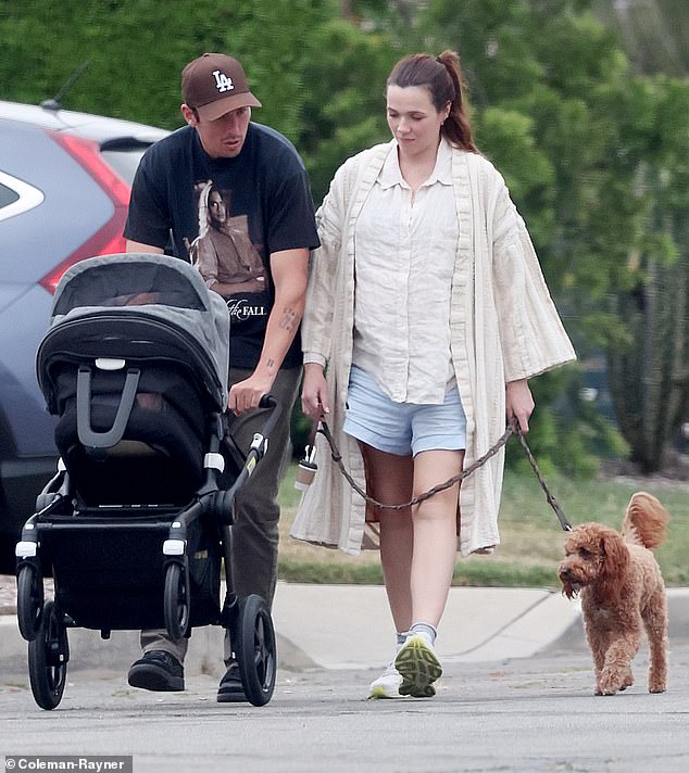 Demi zeigte sich gut gelaunt und hielt sich an der Leine ihres Hundes fest, während Andrew einen neu gekauften Kinderwagen schob