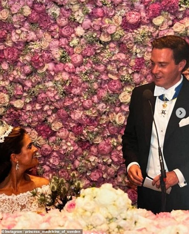 Chris wandte sich während des Empfangs mit einer Ansprache an seine Gäste und seine Braut.  Der Raum war mit Rosen und Pfingstrosen geschmückt