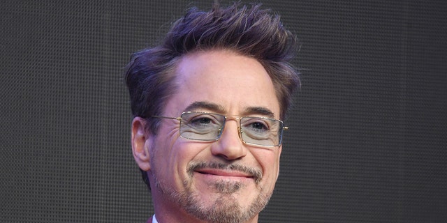 Robert Downey Jr. lächelt mit einer blau getönten rechteckigen Brille auf der Bühne in Seoul, Südkorea