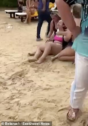 Ein neues Video zeigt eine verstörte Frau am Strand, die von zwei anderen Frauen getröstet wird, kurz nachdem Wladimir zu Tode geprügelt wurde