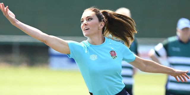 Eine Nahaufnahme von Kate Middleton, die ein blaues Hemd und eine dunkle Hose trägt