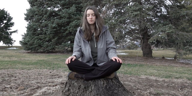 Psychedelic Club president meditates on a stump