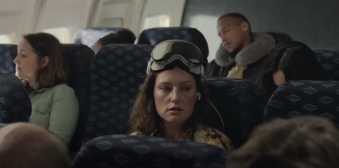 Eine Frau mit Apple Vision Pro im Flugzeug