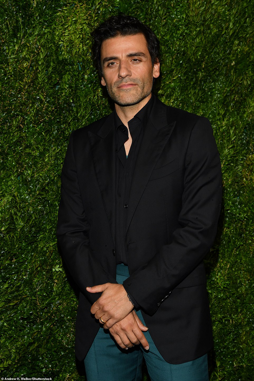 Dapper: Star Wars: The Force Awakens actor Oscar Isaac, 44, looked handsome as ever in a black suit jacket and shirt which he paired with green/blue trousers