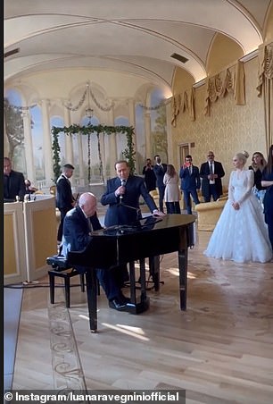 While Berlusconi serenaded the group, accompanied by the piano, his bride and other guests watched him perform (pictured)