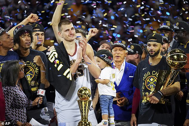 Nuggets-Center Nikola Jokic, Mitte links, feiert mit seinen Teamkollegen Denvers ersten NBA-Titel