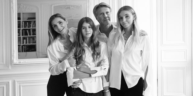 Ein Schwarz-Weiß-Foto von Prinz Emanuele Filiberto mit seiner Frau und seinen beiden Töchtern, alle in weißen Hemden und dunklen Hosen