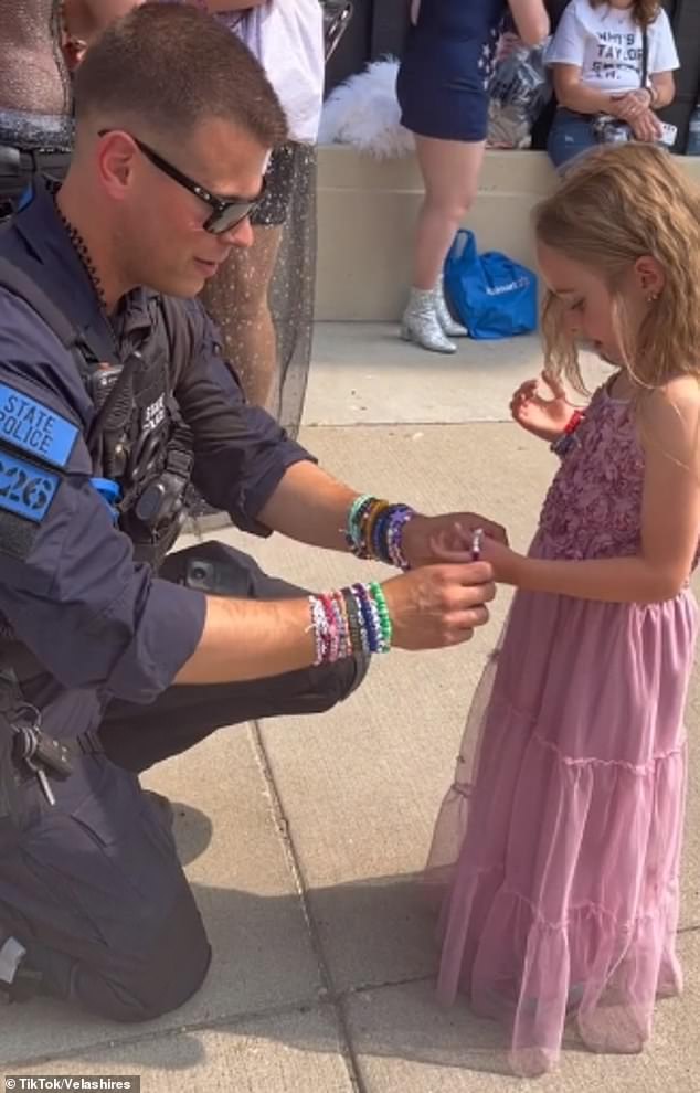 Nachdem er Scarlett bei der Auswahl eines Armbands geholfen hatte, indem er ein lilafarbenes Armband vorschlug, das zu ihrem Kleid passen würde, ist Trooper Justin Roberts zu sehen, wie er es ihr ans Handgelenk legt