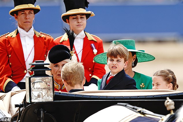 Cheeky Prince Louis looks out at the crowd alongside his siblings, George and Charlotte