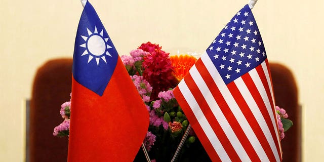 Taiwanesische und amerikanische Flaggen mit Blumen dahinter