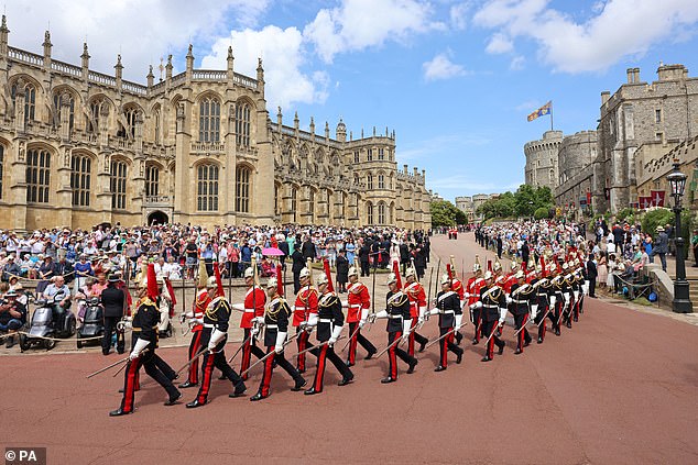 The Life Guards (left) and the Blues and Royals (right) regiments of the Household Cavalry, parade towards St George's Chapel