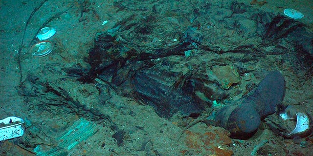 Überreste eines Mantels und von Stiefeln im Schlamm auf dem Meeresboden nahe dem Heck der Titanic