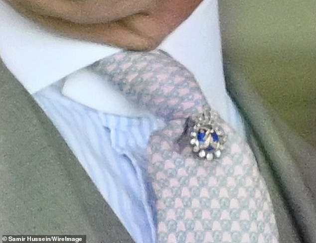 Auch König Charles trug heute eine umwerfende Krawattennadel, als er Royal Ascot besuchte.  Es enthielt eine silberne Krone und einen Saphir-Edelstein sowie einen schimmernden Satz Diamanten