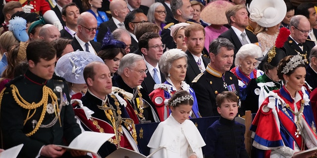 Prinz Harry sitzt während der Krönung seines Vaters in einer Menschenmenge