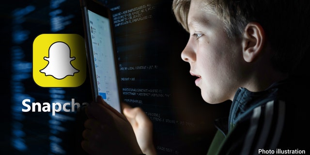 A 12-year-old boy looks at a iPad screen 