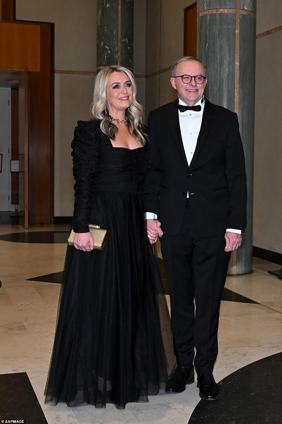 Anthony Albanese posierte in seiner schwarzen Krawatte mit seiner Partnerin Jodie Haydon, die ein langärmliges schwarzes Kleid mit Rüschen, gepaart mit einer goldenen Halskette und einem passenden Verschluss trug (im Bild).