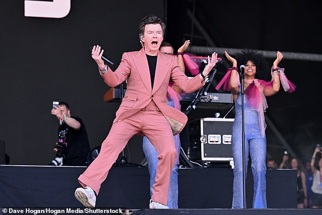 Legend: The pop legend, 57, dressed to impress in a salmon pink suit at he worked the stage and put on a show for thousands of fans gathered at Worthy Farm