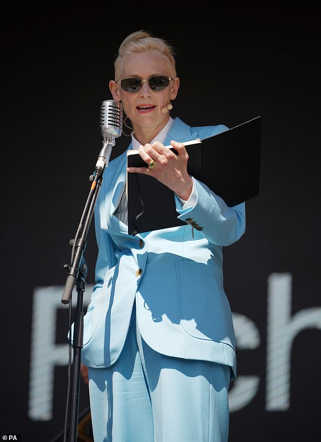 Taking centre stage: Tilda donned dark sunglasses and was seen reading from the folder as she participated in the festival