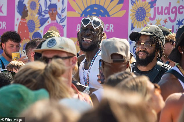 Great times: Stormzy appeared to be in jovial spirits as he sang along to Aitch's hits, joining other festivalgoers in the crowds as he left the backstage area