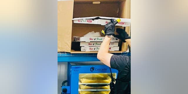 LAPD-Beamter inspiziert Pizzakarton
