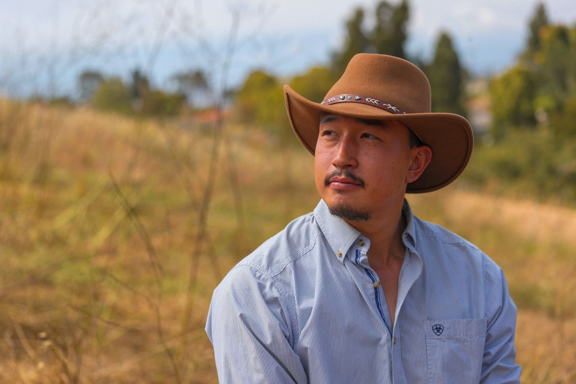 Ziegenhirte Michael Choi trägt einen Cowboyhut