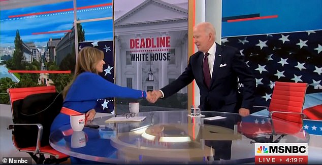 Präsident Joe Biden (rechts) steht auf, um Nicolle Wallace (links) von MSNBC die Hand zu schütteln, bevor er das Studio verlässt, während sie noch auf Sendung war